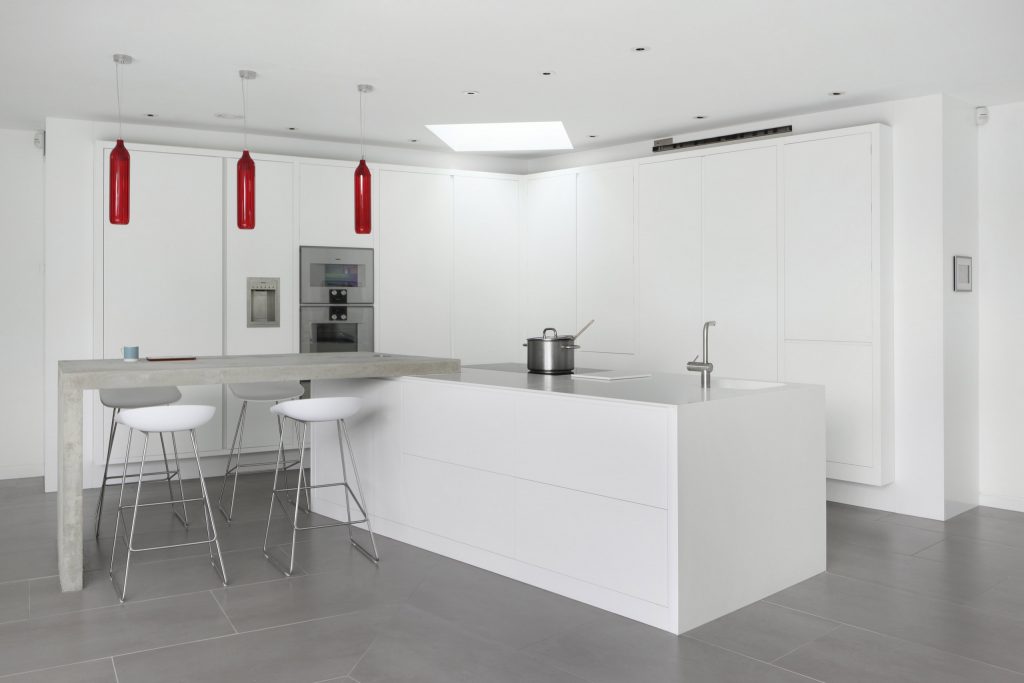 Matt Laquered White Kitchen Cabinetry Island with Contemporary Concrete Breakfast Bar