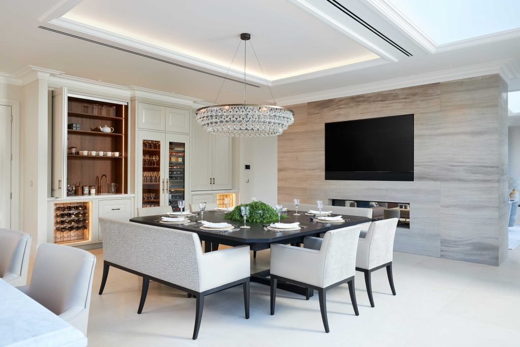 The bar and wine storage areas which, alongside the bronze open wine racks with feature LED lighting, also includes a Gaggenau Wine Fridge and glazed glassware display cabinet, Retractable dresser cabinets open back to reveal a drink preparation area with antique brass Quooker Boiling Water tap and sink and warm LED Lighting throughout helps set the mood.