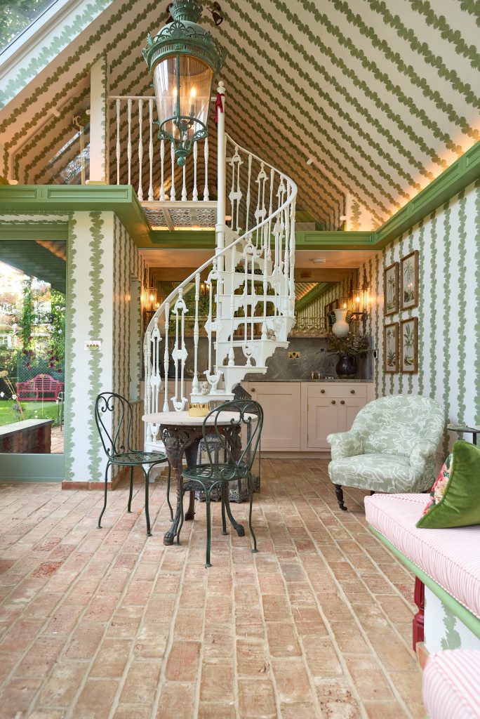 A wide-angle image showcasing the kitchen beneath the iron staircase in 'Little Kew,' ideally with soft natural light and visible garden views.
